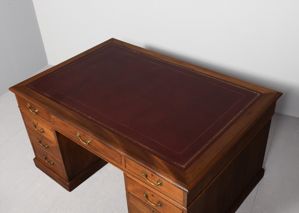 A large Victorian mahogany partners desk with a brown leather inset writing surface, twin pedestals with drawers, and brass swan-neck drop handles. View VII