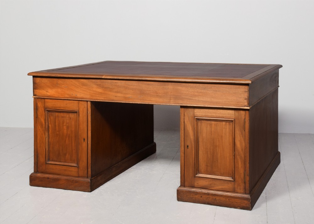 A large Victorian mahogany partners desk with a brown leather inset writing surface, twin pedestals with drawers, and brass swan-neck drop handles. View VIII