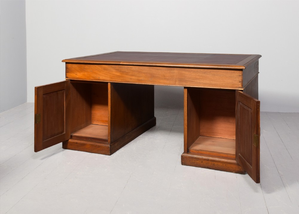 A large Victorian mahogany partners desk with a brown leather inset writing surface, twin pedestals with drawers, and brass swan-neck drop handles. View IX