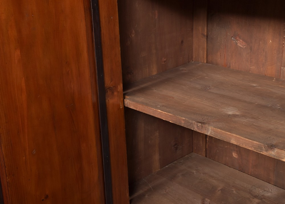 A tall two-door freestanding armoire in figured walnut veneer with shaped door panels, a straight moulded cornice, and plinth base with bracket feet. View VI