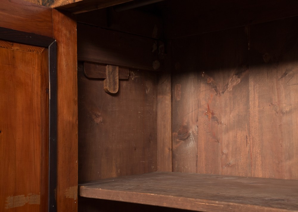 A tall two-door freestanding armoire in figured walnut veneer with shaped door panels, a straight moulded cornice, and plinth base with bracket feet. View VIII