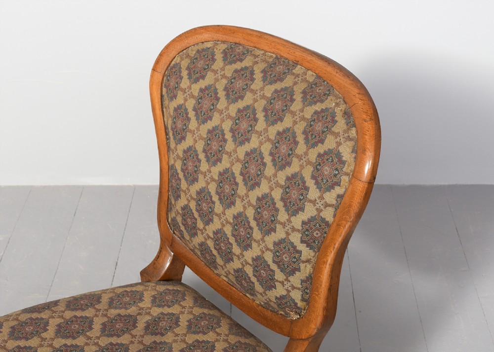 A set of twelve French carved oak dining chairs with balloon backs, cabriole legs, and red velvet or patterned fabric upholstery. View VIII