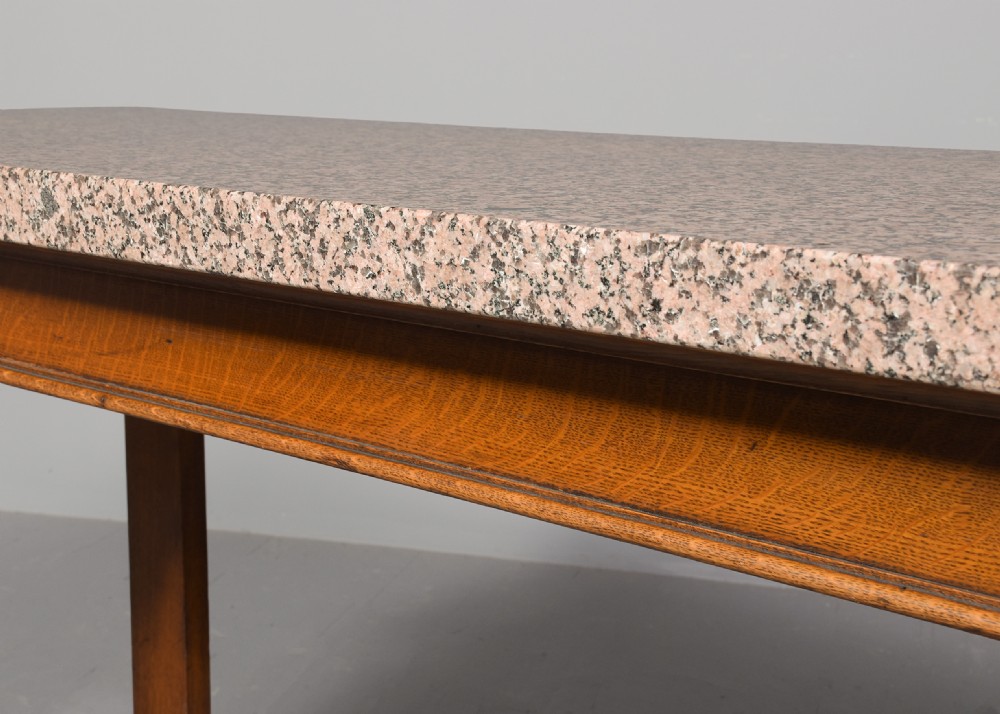 An antique oak console table featuring a polished pink granite top and heavy carved scroll legs ending in carved paw feet. View IV