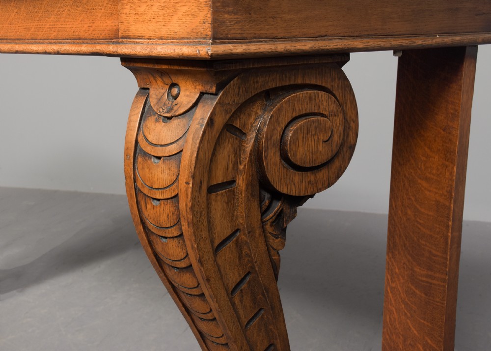 An antique oak console table featuring a polished pink granite top and heavy carved scroll legs ending in carved paw feet. View VI
