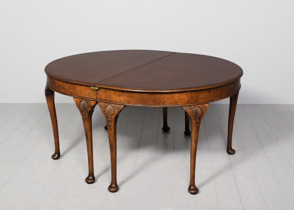 A George II style walnut extending dining table with carved cabriole legs, shell-detailed knees, and pad feet. View VIII