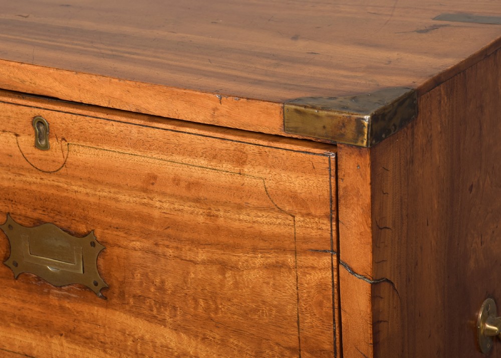 A two-part 19th-century camphor wood campaign chest featuring flush brass corners, recessed brass handles, and turned bun feet. View IV