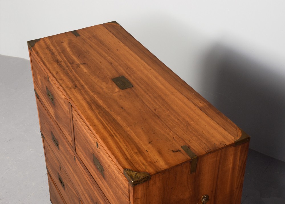 A two-part 19th-century camphor wood campaign chest featuring flush brass corners, recessed brass handles, and turned bun feet. View VIII