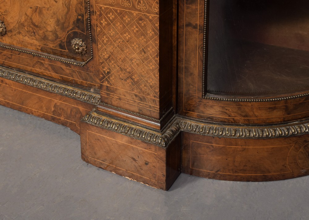 A Victorian burr walnut credenza featuring curved glazed end display sections, twin central cupboard doors decorated with blue Jasperware plaques, and gilt metal mounts. View IV