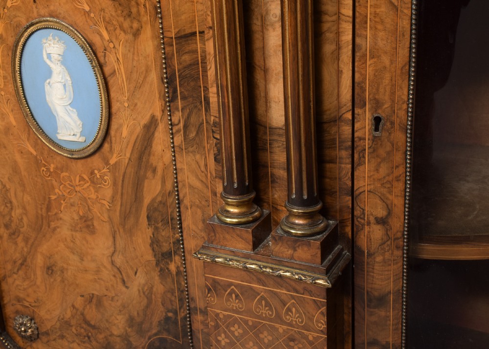 A Victorian burr walnut credenza featuring curved glazed end display sections, twin central cupboard doors decorated with blue Jasperware plaques, and gilt metal mounts. View VIII