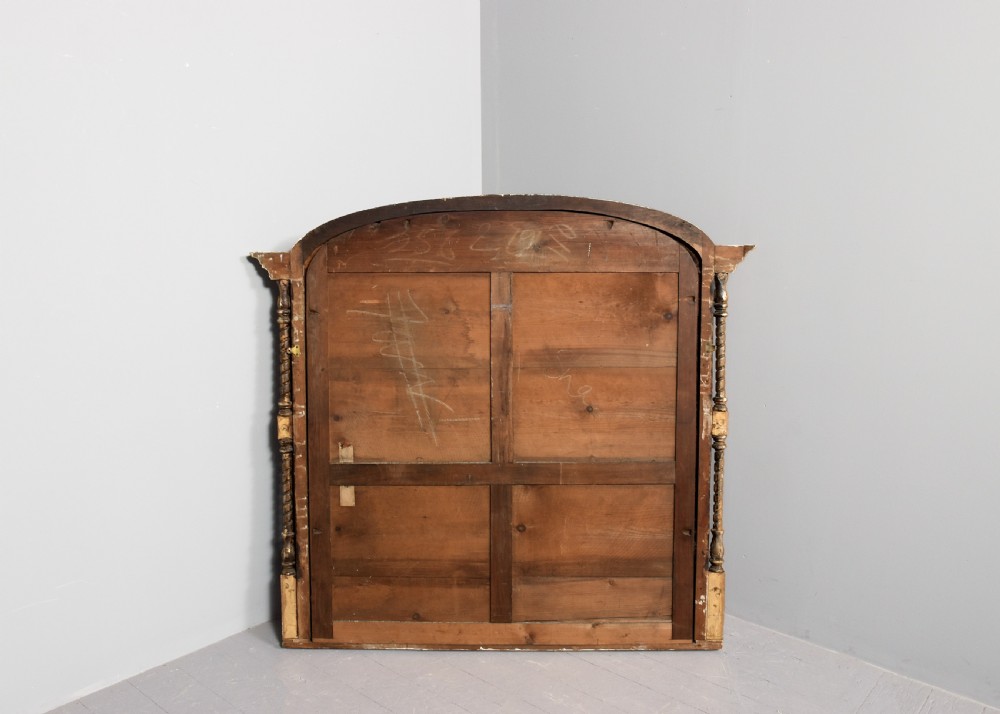 An arched antique giltwood overmantel mirror featuring beaded moulding and detailed side columns. View VIII