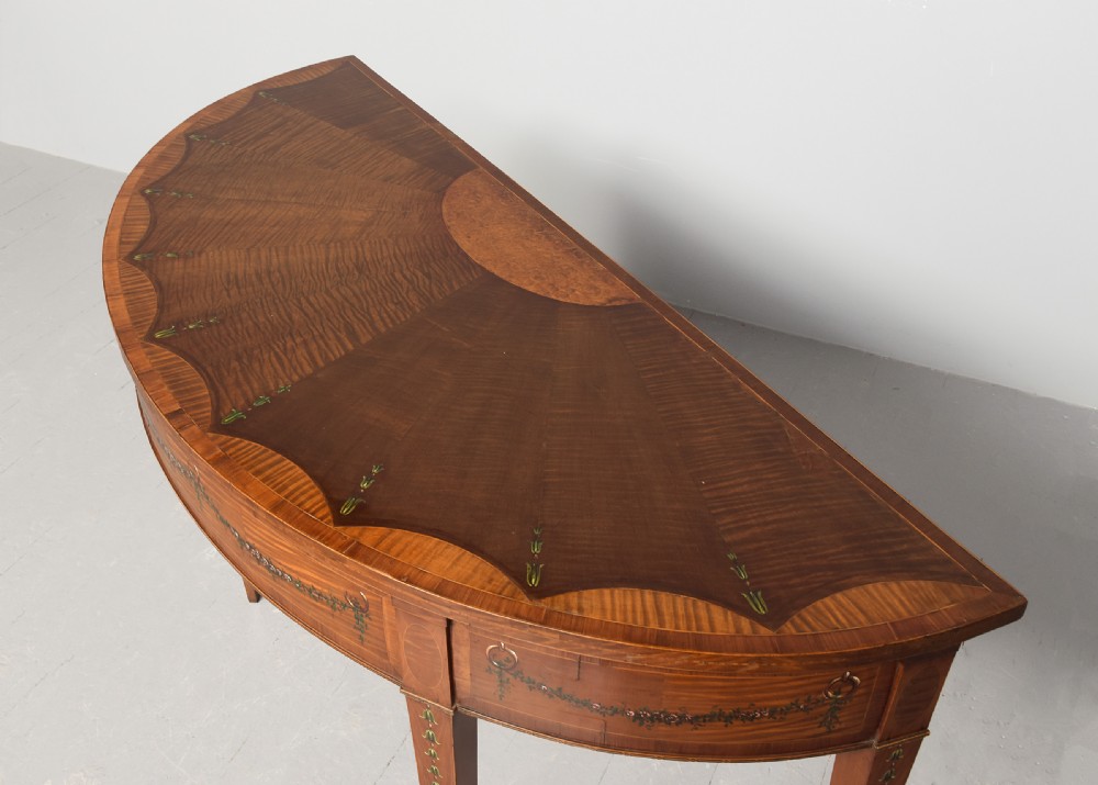 A George III semi-circular satinwood serving table with painted floral garlands along the apron and tapered legs. View III