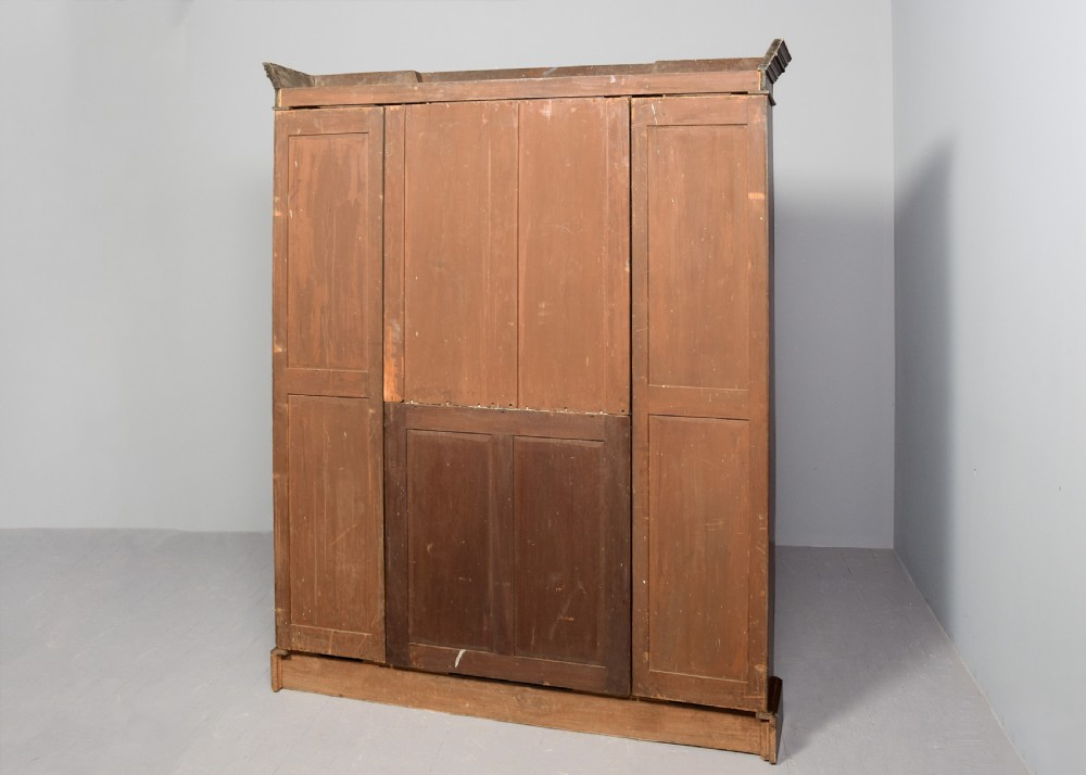 A tall Victorian breakfront open bookcase in pollard oak featuring three sections and grey painted backboards. View VIII