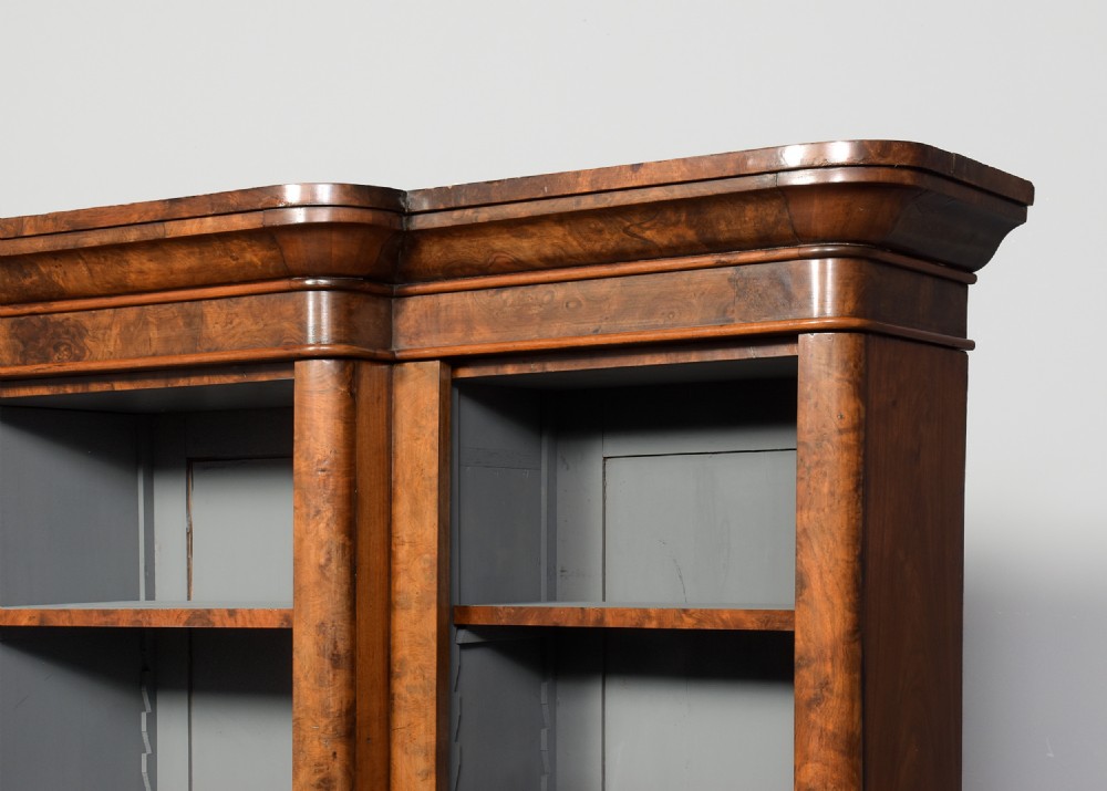 A mid-Victorian burr walnut breakfront open bookcase featuring three bays with adjustable shelves and a moulded cornice. View III