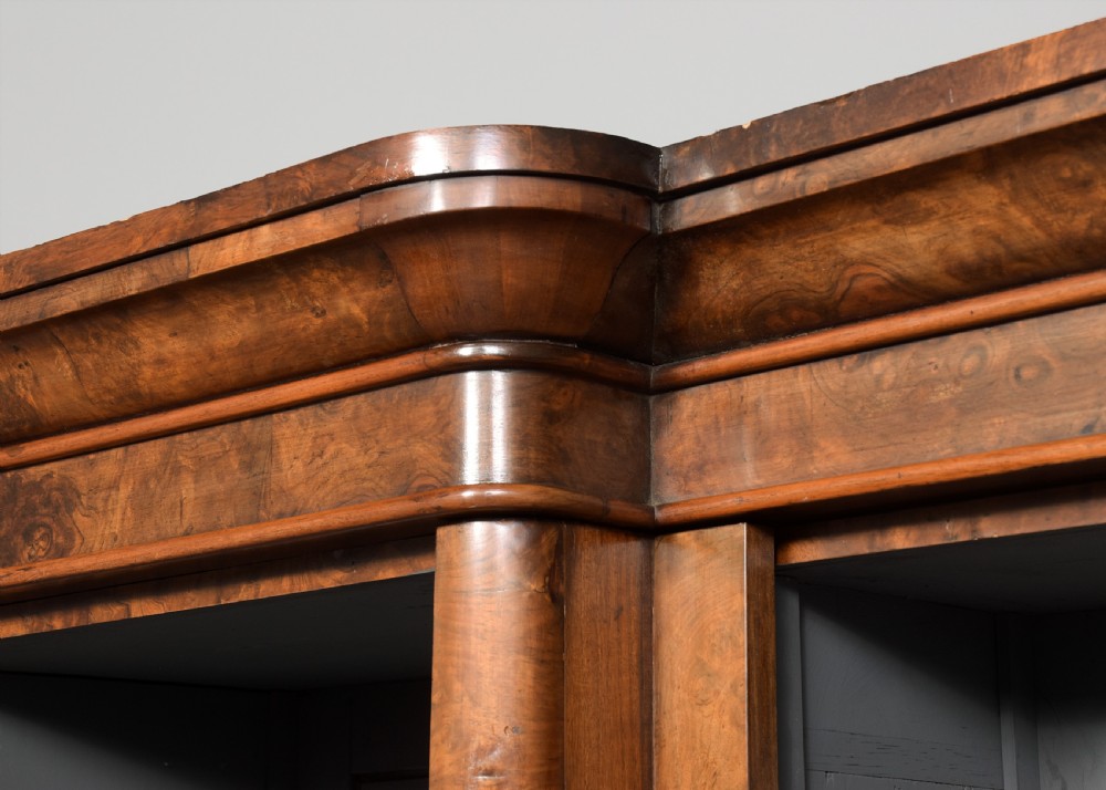 A mid-Victorian burr walnut breakfront open bookcase featuring three bays with adjustable shelves and a moulded cornice. View VI