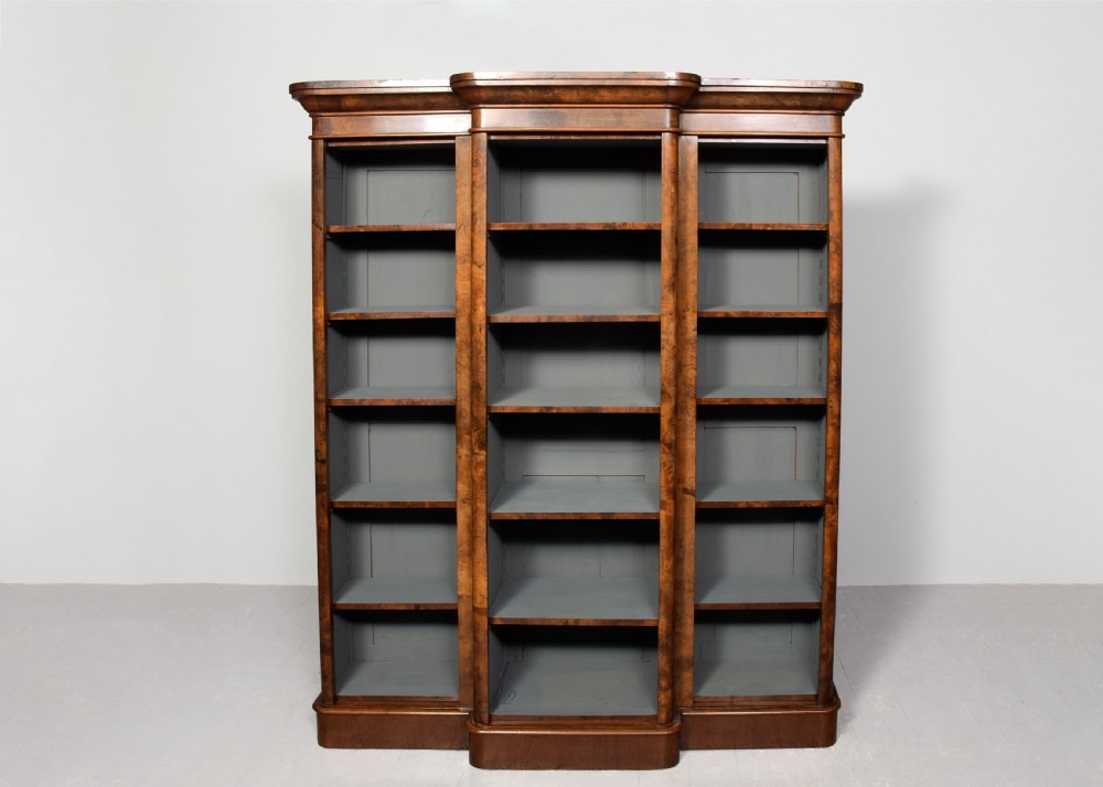 A mid-Victorian burr walnut breakfront open bookcase featuring three bays with adjustable shelves and a moulded cornice. View VII