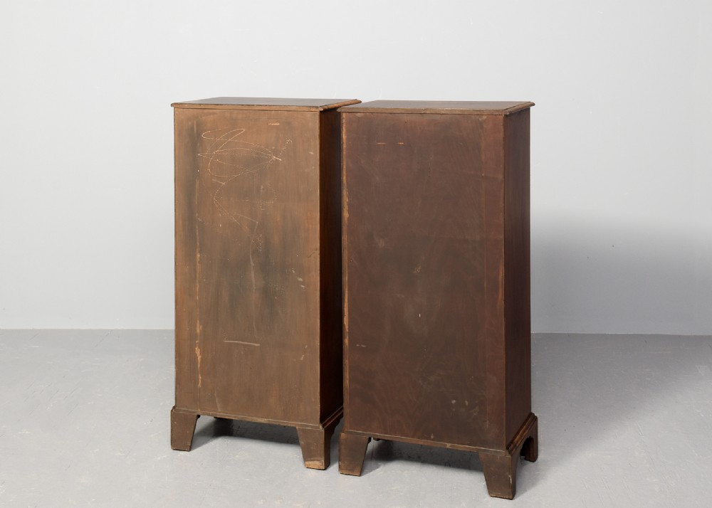A pair of tall, narrow George III style walnut chests of drawers featuring figure-matched veneer fronts, brass swan-neck handles, and bracket feet. View VI