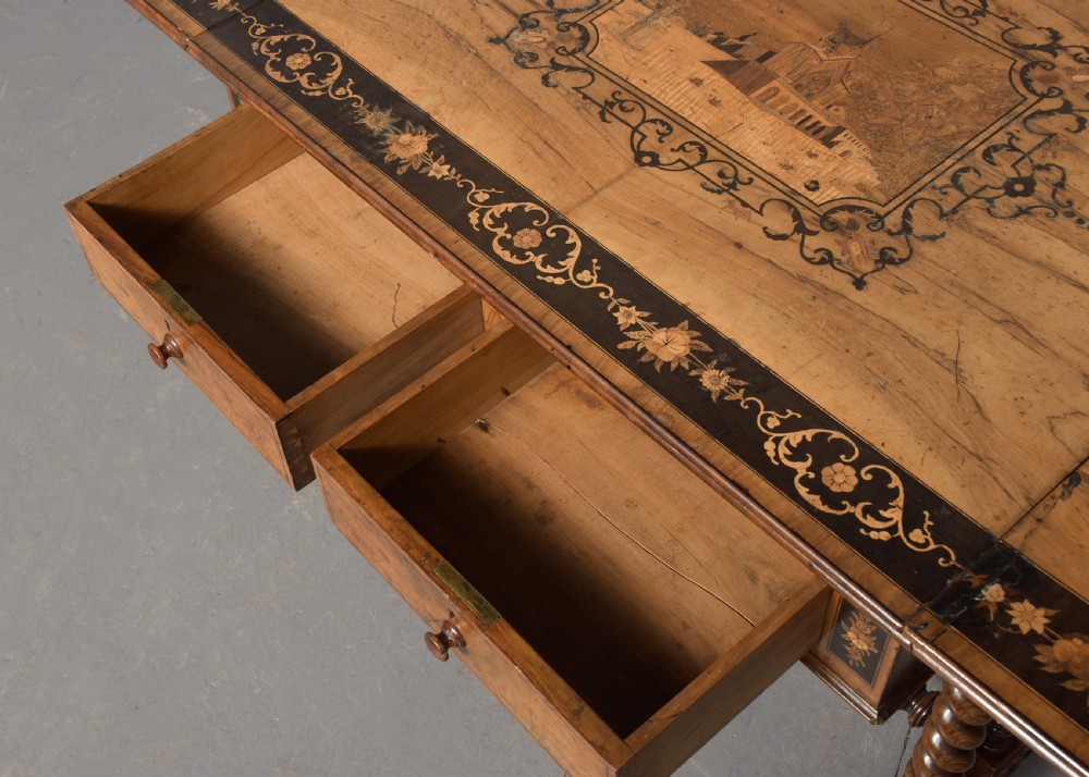 An Italian Sorrento olivewood sofa table featuring intricate marquetry figure inlays, drop-leaf side flaps, two drawers, and barley twist legs connected by a turned stretcher. View IV