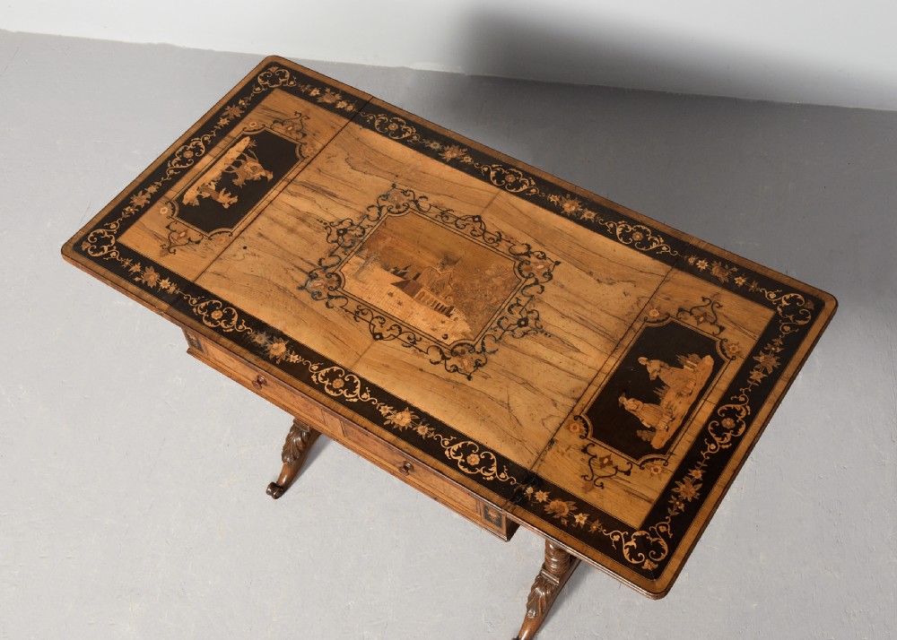 An Italian Sorrento olivewood sofa table featuring intricate marquetry figure inlays, drop-leaf side flaps, two drawers, and barley twist legs connected by a turned stretcher. View VI