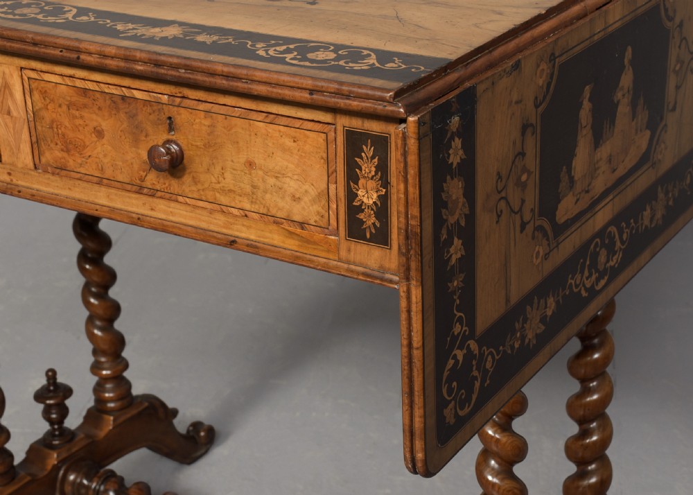 An Italian Sorrento olivewood sofa table featuring intricate marquetry figure inlays, drop-leaf side flaps, two drawers, and barley twist legs connected by a turned stretcher. View IX