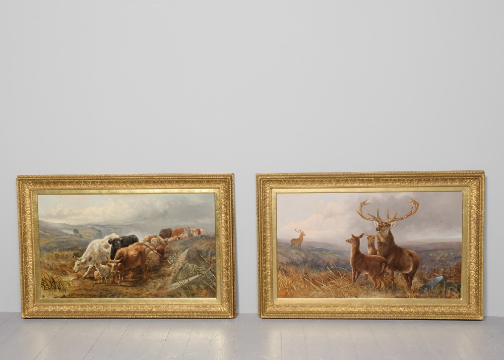 A pair of large Victorian oil paintings in ornate gilt frames depicting Scottish Highland landscapes with livestock and deer.
