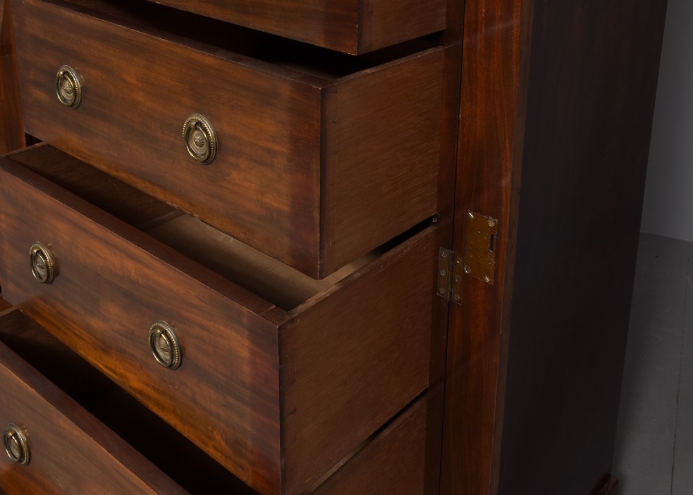 A pair of tall Victorian mahogany Wellington chests, each featuring six graduated drawers with brass handles and side locking stiles set on a plinth base. View II