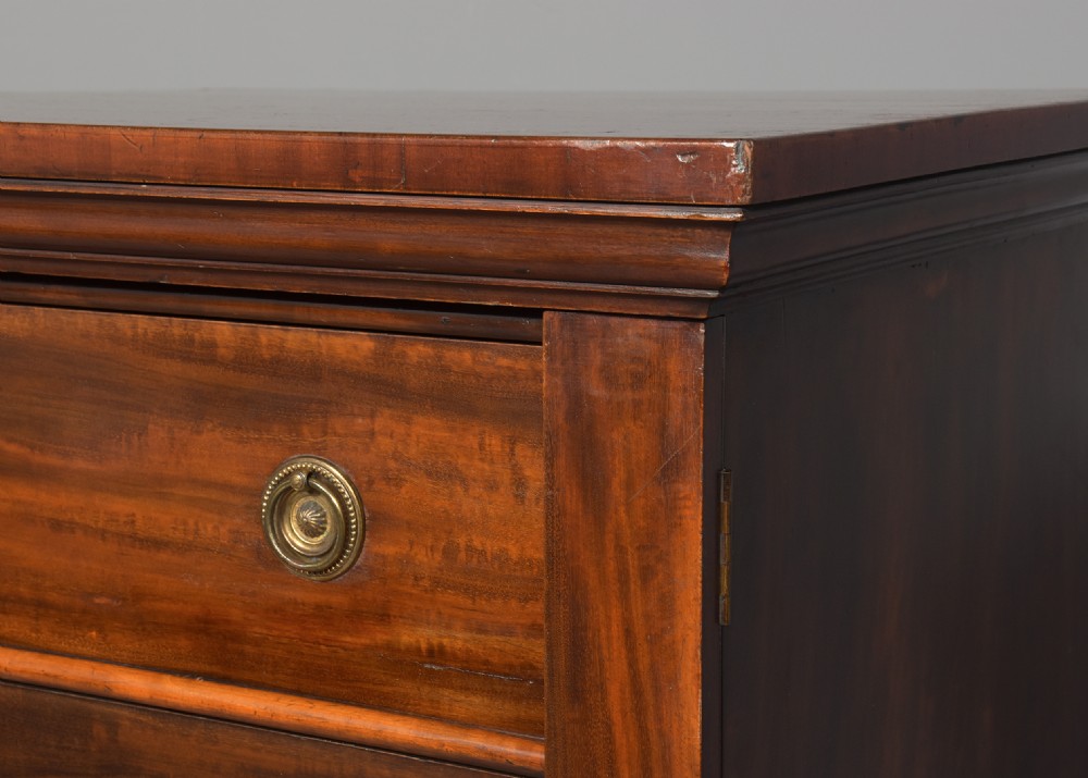 A pair of tall Victorian mahogany Wellington chests, each featuring six graduated drawers with brass handles and side locking stiles set on a plinth base. View V