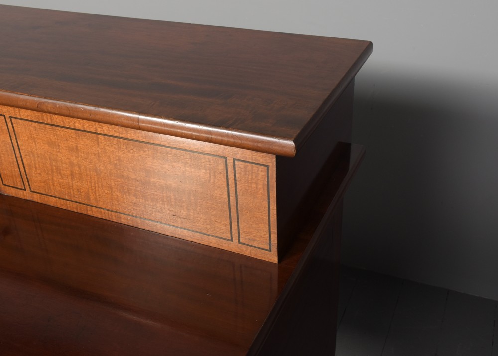 A George III mahogany stage-back sideboard featuring a raised upper tier, oval inlay detailing, brass lion-mask ring pulls, and tapered square legs. View V