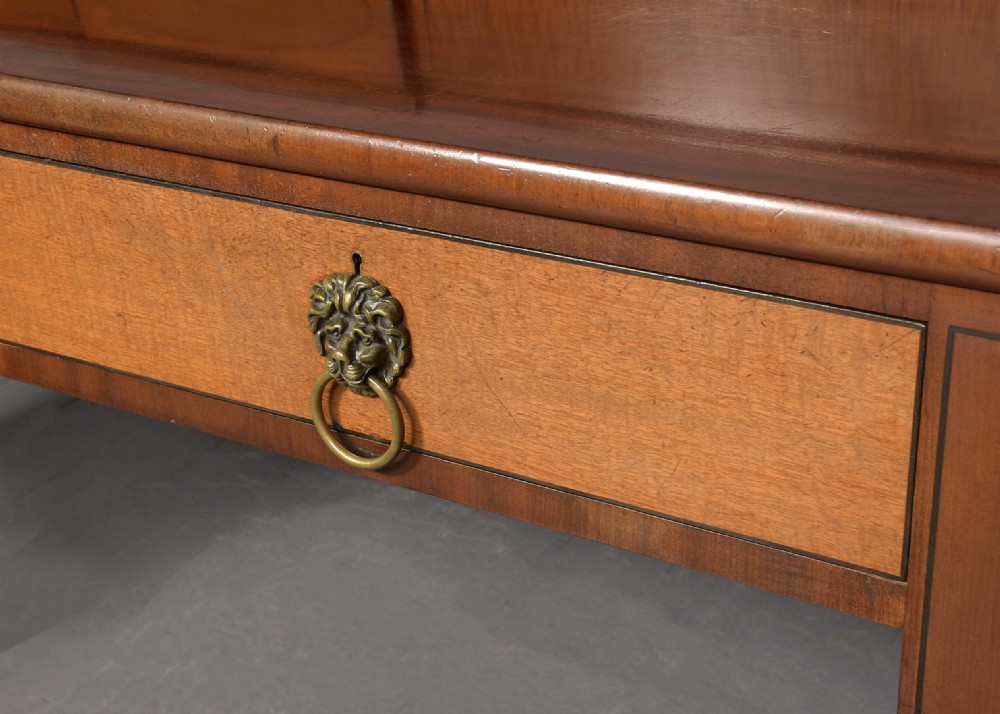 A George III mahogany stage-back sideboard featuring a raised upper tier, oval inlay detailing, brass lion-mask ring pulls, and tapered square legs. View VII