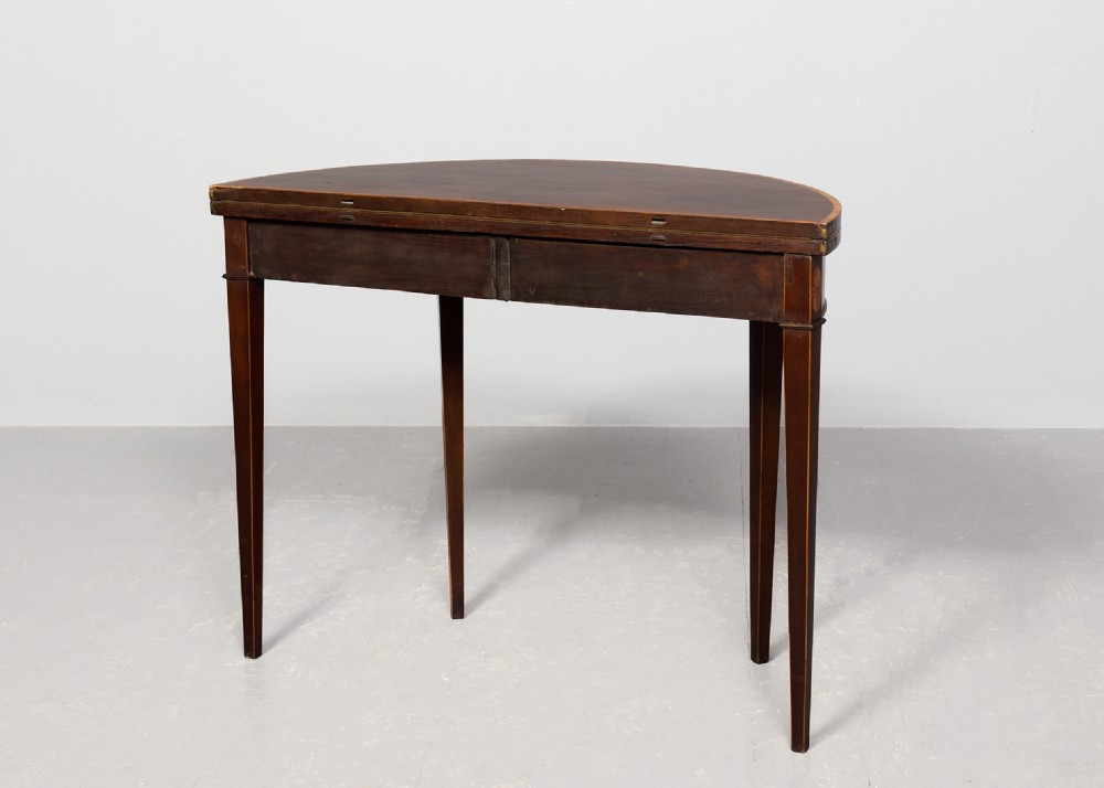 A George III semi-circular mahogany card table with satinwood inlay and square tapered legs. View IX