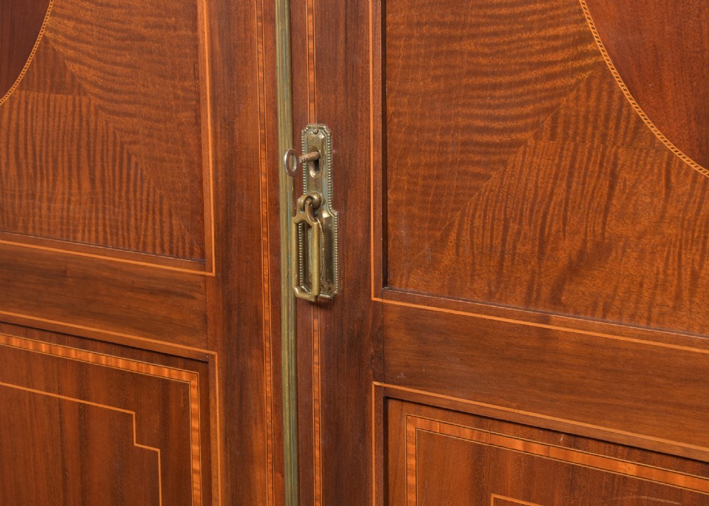 A two-door Georgian style mahogany wardrobe featuring flame mahogany oval veneer panels, fine boxwood stringing, and bracket feet. View III