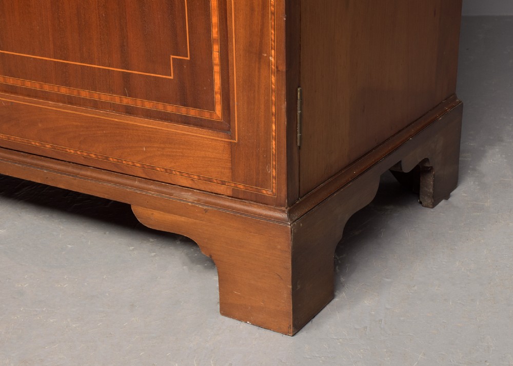 A two-door Georgian style mahogany wardrobe featuring flame mahogany oval veneer panels, fine boxwood stringing, and bracket feet. View IV