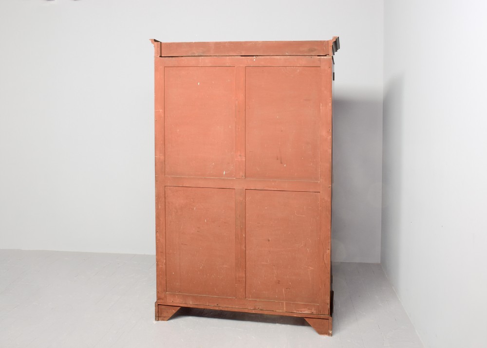 A two-door Georgian style mahogany wardrobe featuring flame mahogany oval veneer panels, fine boxwood stringing, and bracket feet. View VIII