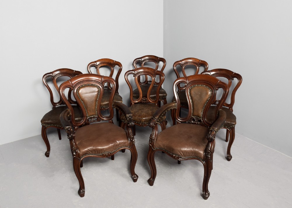 A set of eight Victorian mahogany dining chairs featuring padded leather backs, brass stud detailing, and carved cabriole legs. View II