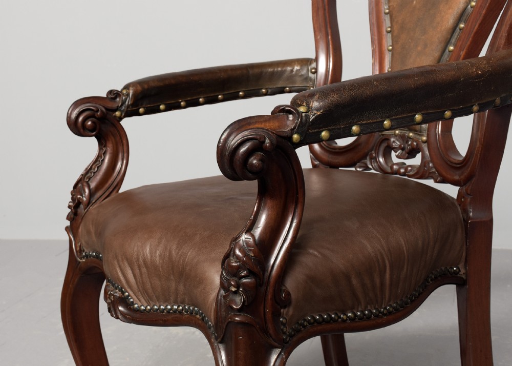 A set of eight Victorian mahogany dining chairs featuring padded leather backs, brass stud detailing, and carved cabriole legs. View V