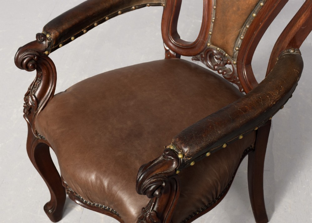 A set of eight Victorian mahogany dining chairs featuring padded leather backs, brass stud detailing, and carved cabriole legs. View VI