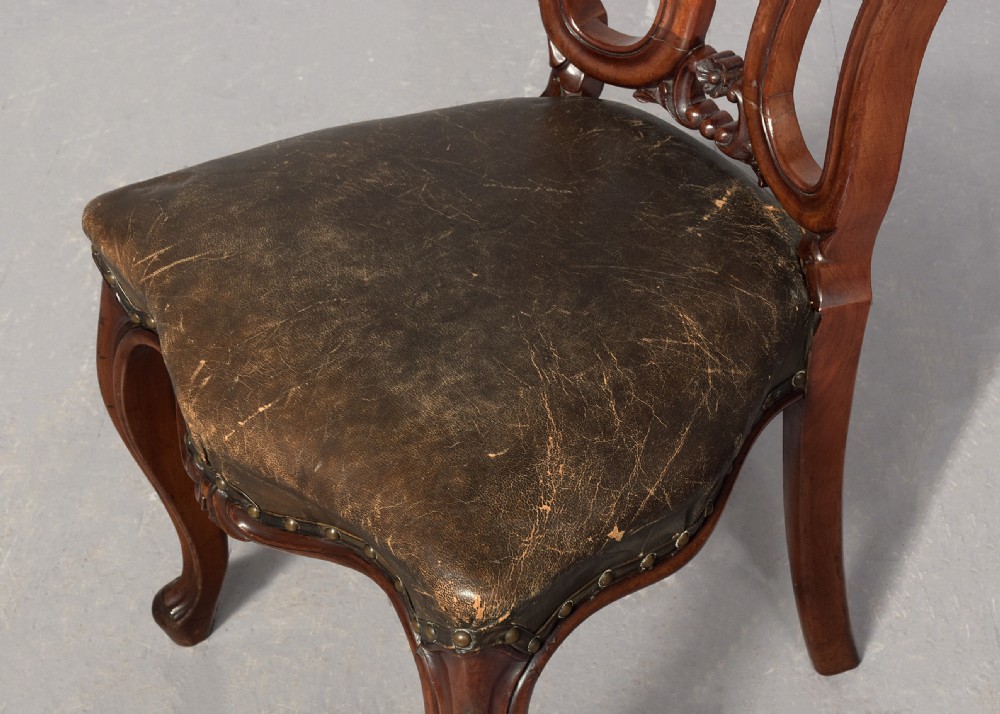 A set of eight Victorian mahogany dining chairs featuring padded leather backs, brass stud detailing, and carved cabriole legs. View XI