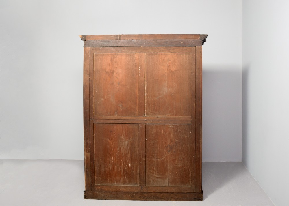 A William IV flame mahogany double wardrobe featuring fielded panel doors, a moulded cornice, and a plinth base. View VIII