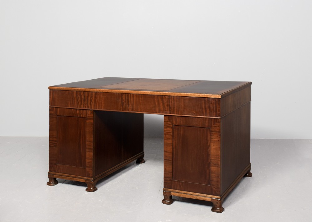 A mahogany three-part pedestal desk featuring a three-panel leather inset top, flame mahogany drawer fronts, turned wooden knobs, and bracket feet. View VIII