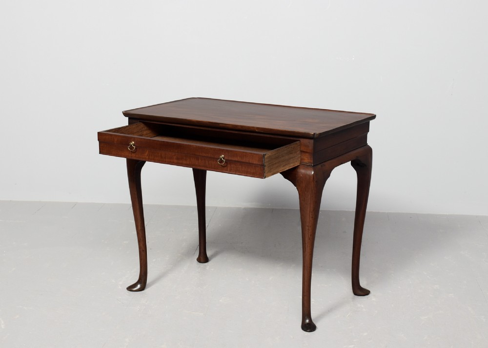 An 18th-century George III mahogany lowboy featuring a single drawer with brass drop handles, a shaped apron, and cabriole legs ending in pad feet. View II
