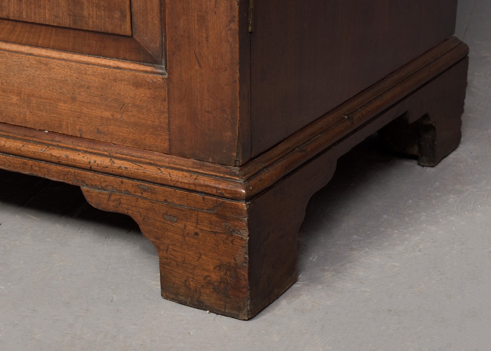 An early George III mahogany press wardrobe featuring two fielded panel doors, a moulded cornice, and bracket feet. View III