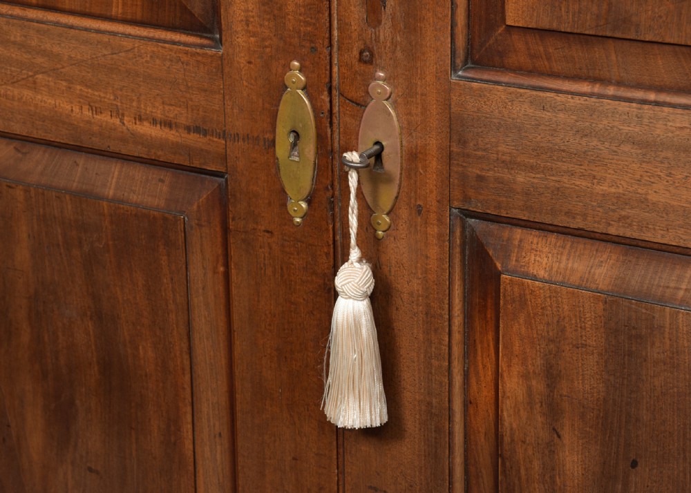 An early George III mahogany press wardrobe featuring two fielded panel doors, a moulded cornice, and bracket feet. View IV