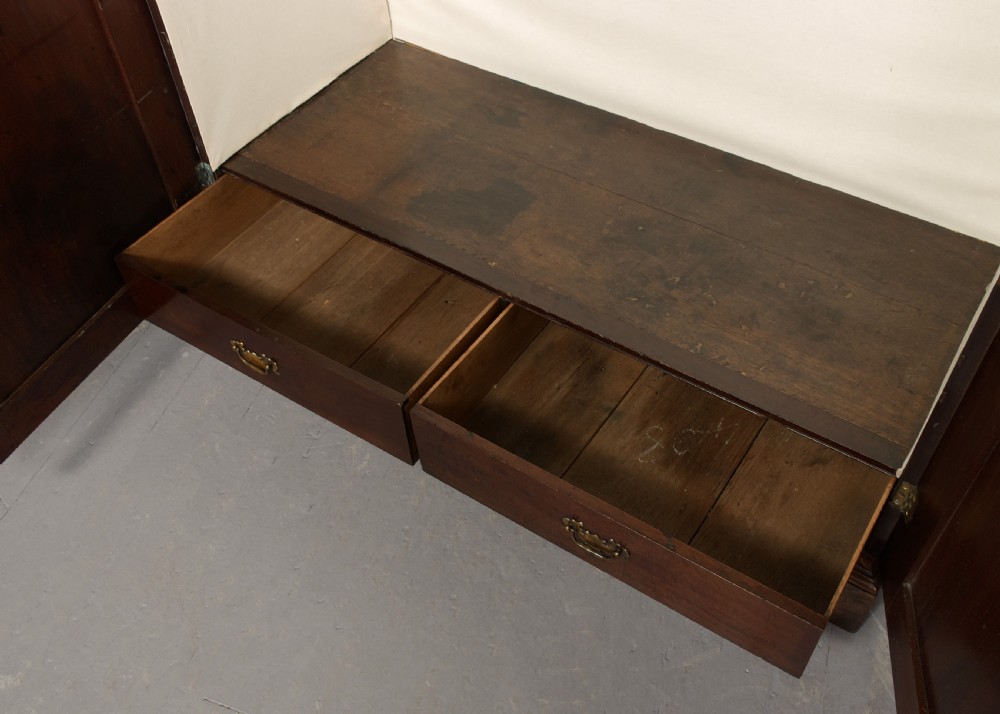 An early George III mahogany press wardrobe featuring two fielded panel doors, a moulded cornice, and bracket feet. View VI