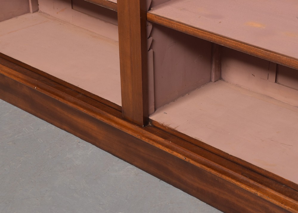 A tall mid-Victorian mahogany open bookcase featuring a double-bay design with adjustable shelves set upon a solid plinth base. View V