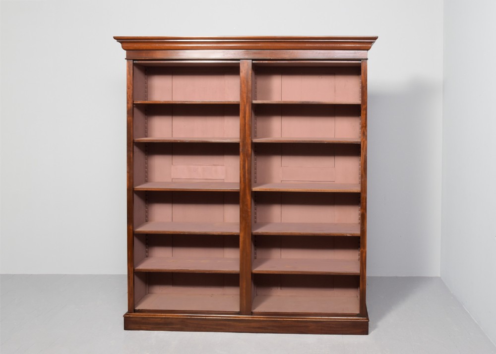 A tall mid-Victorian mahogany open bookcase featuring a double-bay design with adjustable shelves set upon a solid plinth base. View VIII