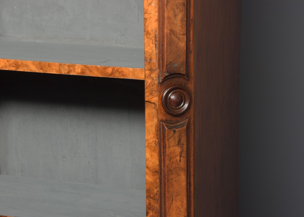 A large three-section Victorian open bookcase made from burr walnut with a breakfront centre section, adjustable shelves, and a plinth base. View VI