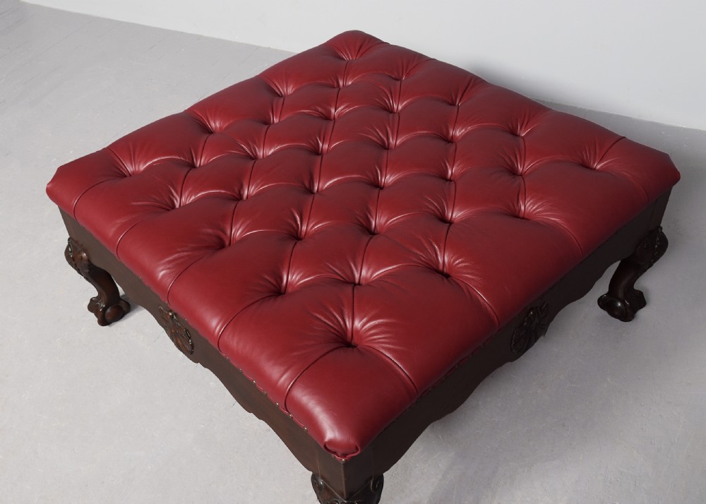 A large square mahogany footstool featuring deep-buttoned burgundy leather upholstery, brass studding, and carved cabriole legs with ball-and-claw feet. View III
