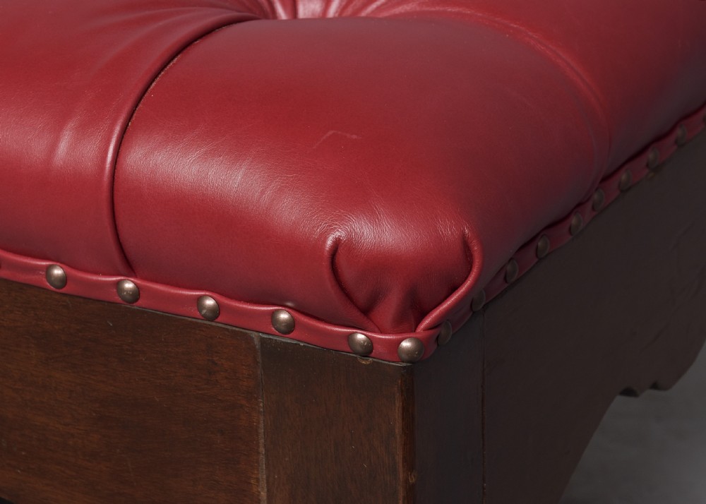 A large square mahogany footstool featuring deep-buttoned burgundy leather upholstery, brass studding, and carved cabriole legs with ball-and-claw feet. View VI