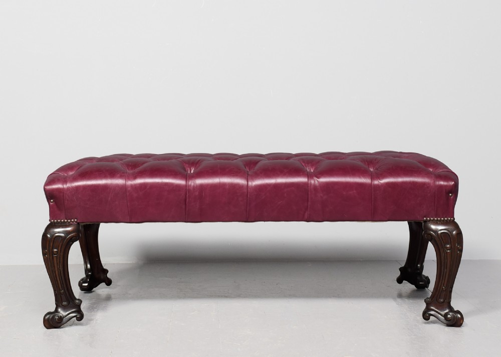 A large rectangular Georgian-style footstool upholstered in deep buttoned burgundy hide leather with mahogany cabriole legs. View VII