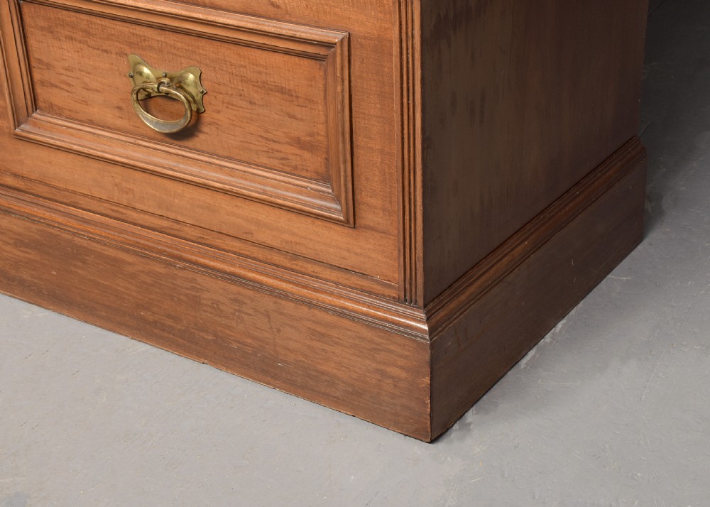A straight-grained walnut three-section wardrobe with two tall mirrored doors flanking a central column containing a small cupboard, open shelf, and multiple drawers. View VII
