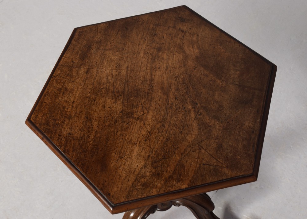 A pair of rosewood occasional tables featuring hexagonal tops, turned carved pedestals, and scrolled tripod legs. View VI